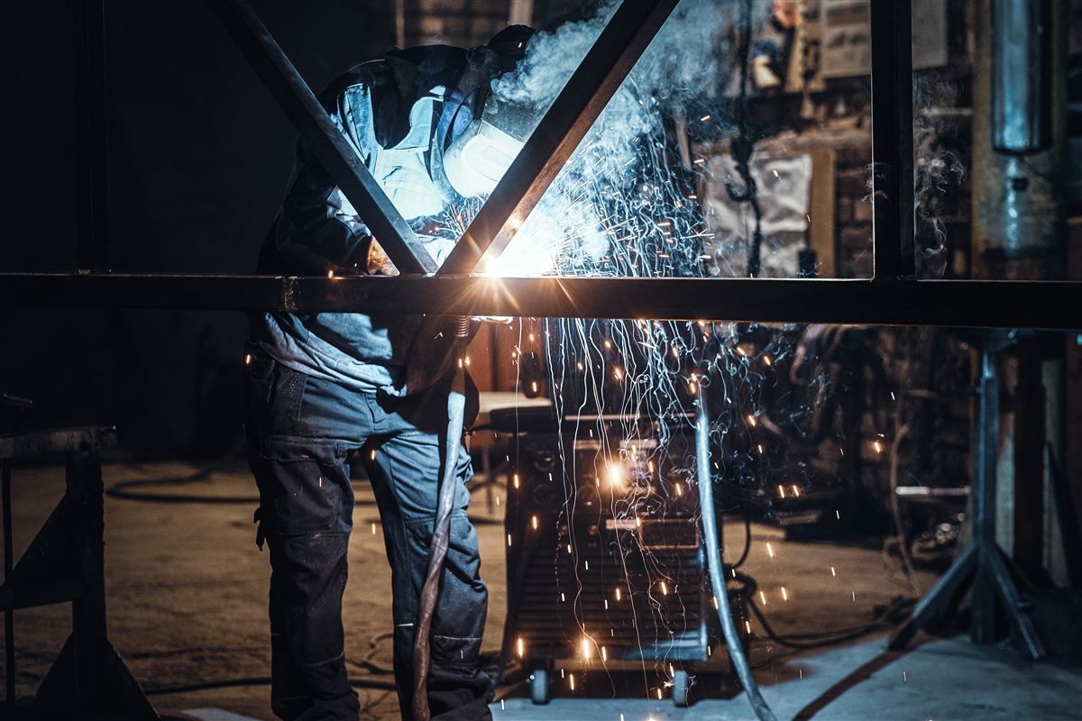 Welder working on steel structure with sparks
